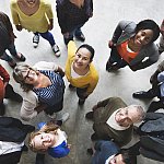 Bird’s-eye view of diverse people looking up and smiling.