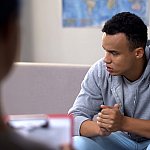 Teenaged boy in session with health professional.