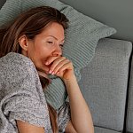 Tired woman lying on sofa.