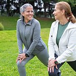 Women stretching together in a park.