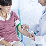 Doctor preparing a woman’s arm for a blood test.