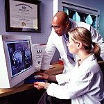 Two researchers looking at an MRI on a computer screen.