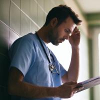 Stressed doctor reading letter
