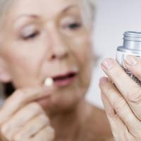 Senior woman holding a bottle of pills
