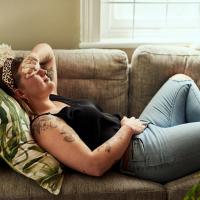 Woman lying on sofa holding her stomach
