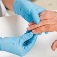 Dermatologist wearing gloves examines the skin of a patient with eczema