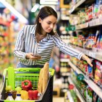 Woman selecting groceries from a shelf.