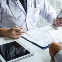 Doctor giving prescription to patient.