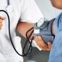 A doctor listening to his patient's heartbeat with a stethoscope