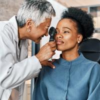 An optometrist performing an eye exam on a female patient