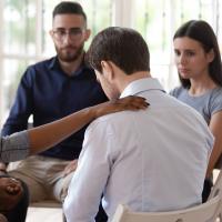 Rear view at upset man feel depression get psychological support