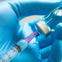 Image of a medical professional filling a syringe 
