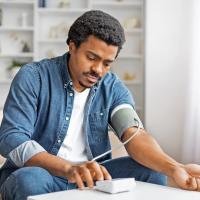 A man measuring his blood pressure at home.