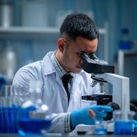 Scientist looking through a microscope in a laboratory.