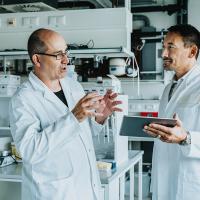 Scientists having discussion while using digital tablet at laboratory