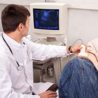Doctor looking for kidney stones with an ultrasound scanner.