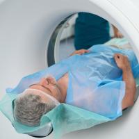 Man undergoing an abdominal CT scan in a clinic.
