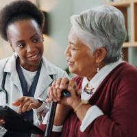 Older woman and doctor discuss medical report. 