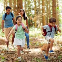 A family walking together on a forest trail.