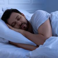 A man sleeping peacefully in bed at night.