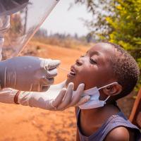 Young African child getting a tongue swab test.