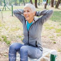 Woman exercises at an outdoor gym. 