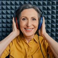 A mature woman wearing headphones for a hearing test.