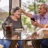 Older couple sitting at a table celebrating great news.